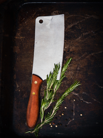Kitchen ax, knife, cleaver, cutter with wooden handle. Axe on dark background with spices. Ax for meat. Vintageの写真素材