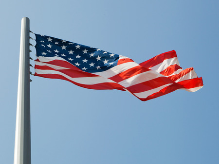 waving american flag over the blue sky