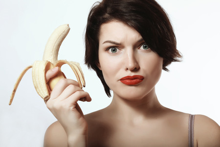 beautiful and sexy brunette with a banana in his handの写真素材