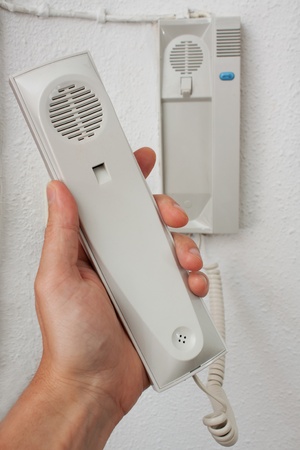 Intercom system with off-hook in his hand near the front door