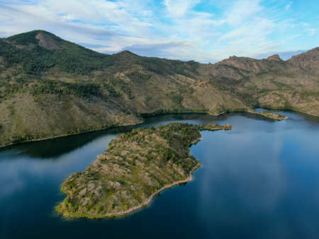 island on a lake in the mountainsの写真素材