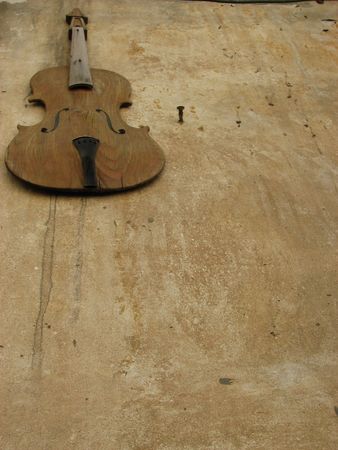 Old violin attached to the brown wall の写真素材