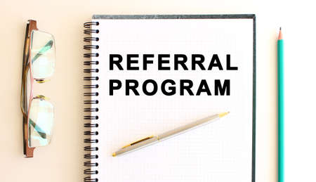 Notepad with text on a white background, near glasses and pencil. Business concept.の写真素材