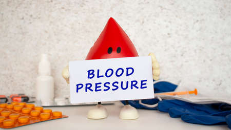 A toy drop of blood holds a white business card with the inscription.