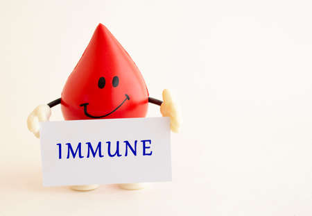 A toy drop of blood holds a white business card with the inscriptionの写真素材