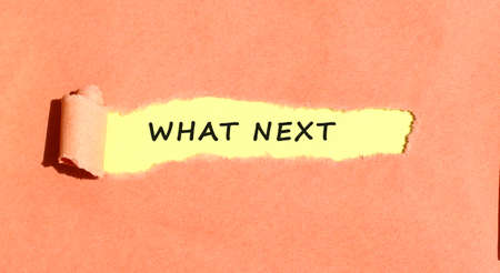 The text appearing on yellow paper behind torn color paperの写真素材