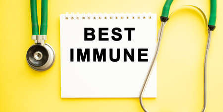 Text BEST IMMUNE on notebook with stethoscope on yellow background. Medical concept.の写真素材
