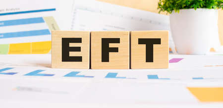 ETF word on wooden cubes. The background is a business graphs. Finance conceptの写真素材