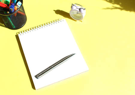 Notebook with blank space for text with stationery. Yellow background color. Business concept.