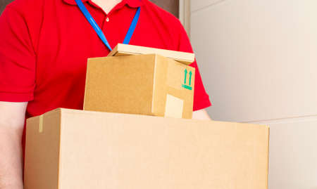 The man has delivered and is holding cardboard boxes. Fast and free shipping. Online shopping and express delivery. Quarantineの写真素材