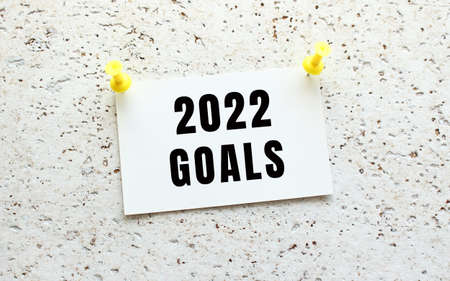2022 GOALS is written on a card attached to a white textured wall with a button. Office reminder.の写真素材