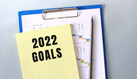 2022 GOALS text written on notepad with pencil. Notepad on a folder with diagrams.の写真素材