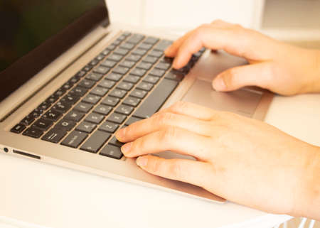 A young woman is in a room and works using a laptop at home. Remote work concept, freelancing.の写真素材