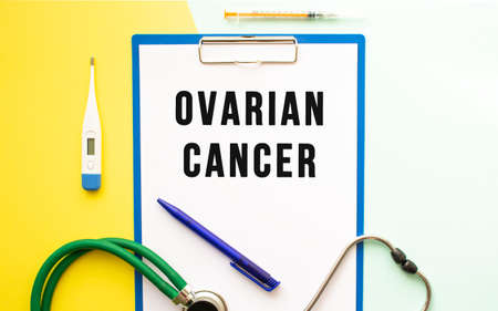 OVARIAN CANCER text on a letterhead in a medical folder on a beautiful background. Stethoscope, thermometer and pen.の写真素材