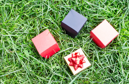 Gift boxes are scattered on the green grass in the park. Holiday concept, sale.の写真素材