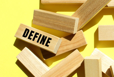 The DEFINE text is written on one of the many scattered wooden blocks, against a yellow background. business concept.の写真素材