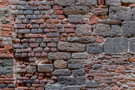 Fragment of wall made of stone blocks and bricks of various size and shape, abstract architectureの写真素材