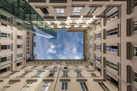 Bottom up view from the rectangular courtyard of a modern high-rise building, Vienna, Austriaの写真素材