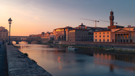 Arno river embankment with Ponte Vecchio bridge and buildings of old city at sunset, Florence, Italyの写真素材