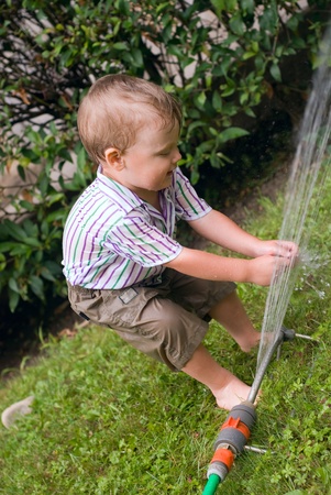 a little boy playing with waterの写真素材