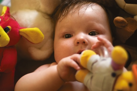a baby surrounded by toysの写真素材