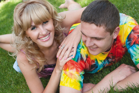 Teenage boy and girl lying in the grassの写真素材
