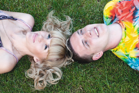 Teenage boy and girl lying in the grassの写真素材