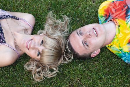 Teenage boy and girl lying in the grassの写真素材