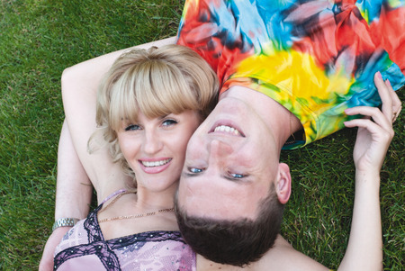Teenage boy and girl lying in the grassの写真素材