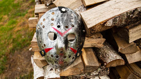 Creepy steel hockey mask lays on the ground near with woodsの写真素材