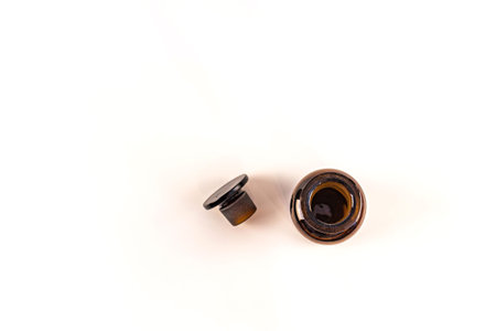 Brown medical jar with a glass stopper on a white background with a label