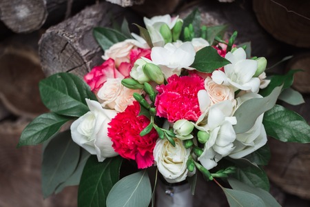 Wedding bouquet of roses, freesias and carnations on a background of woodの写真素材