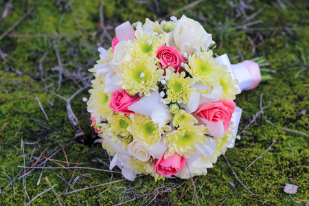 Wedding bouquet of rose, chrysanthemum , iris, and gypsophila on the forest mossの写真素材