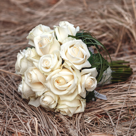 Bridal bouquet of white roses on a faded grassの写真素材