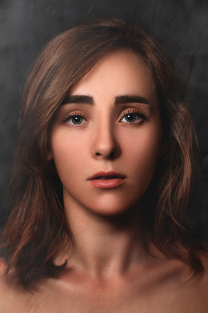 Close Up dramatic portrait of a young girl on a dark background. low key. dark artの写真素材