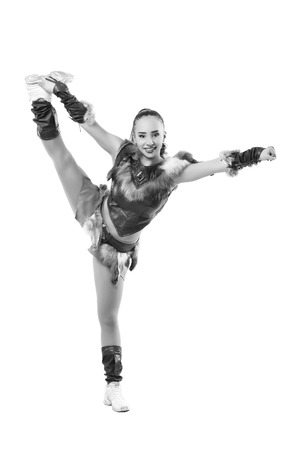 Young professional cheerleader dressed in a warrior costume  standing on one leg . Vertical splits. Black and white photographyの写真素材