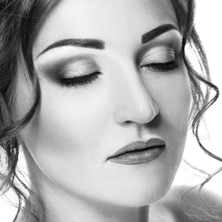 Closeup beauty portrait of beautiful young woman with closed eyes, isolated on white background. Black and white photographyの写真素材
