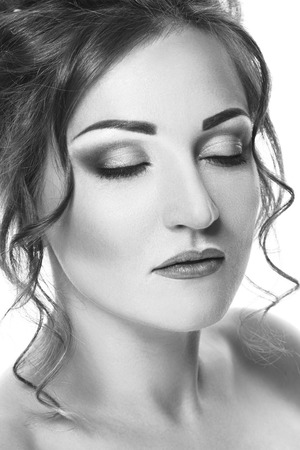 Closeup beauty portrait of beautiful young woman with closed eyes, isolated on white background. Black and white photographyの写真素材