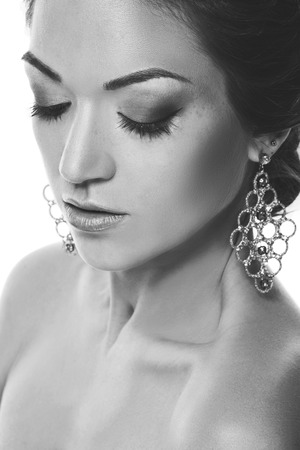 Closeup beauty portrait of beautiful young woman with closed eyes,woman with jewelry, isolated on white background. Black and white photographyの写真素材