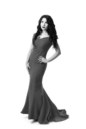 Elegant brunette girl in a black curly hair in a red evening dress. Isolated on white backgroundの写真素材
