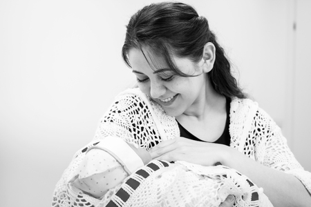 Young mother looking at newborn daughter.Black and white photographyの写真素材