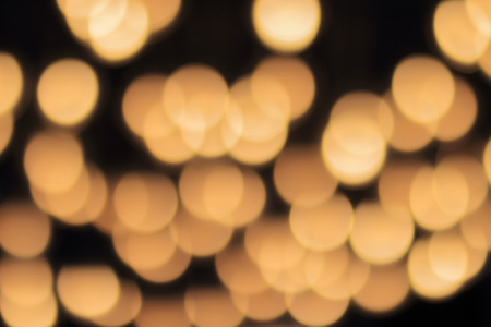 golden bokeh on a black background, abstract dark backdrop with defocused warm lights