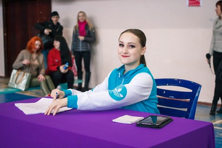 Kamenskoye, Ukraine - March 9, 2017: Championship of the city of Kamenskoye in cheerleading, Judges fill out the competition records, and count the points in the scorecards, referee is smilingのeditorial素材