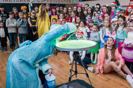 Kamenskoye, Ukraine - December 26, 2016: Christmas party for federation of cheerleading in Kamenskoye, woman in the form of a Snow Maiden blows soap bubbles, a show of soap bubblesのeditorial素材