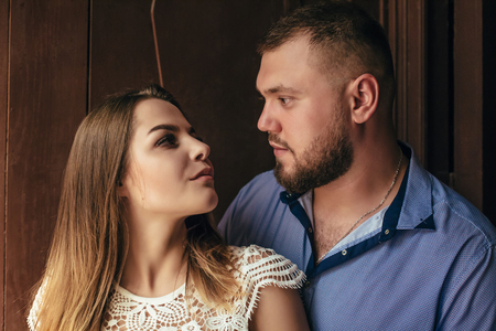 guy and girl look at each other, portrait of a romantic couple,man and woman kissing in a dramatic light, girl holding flowers in hands, young beautiful bride in white dress holding wedding bouquetの写真素材