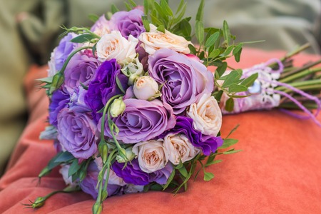 wedding bouquet on an orange pillow, bouquet of bride from rose cream spray, rose bush, rose purple Memory Lane, violet eustoma, eucalyptus の写真素材