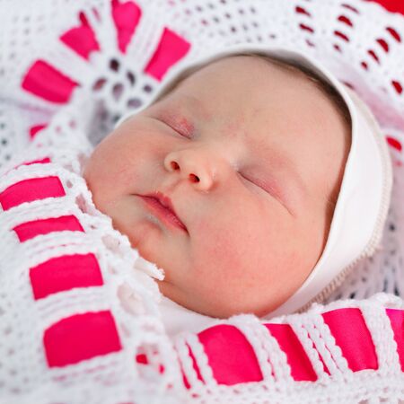 Newborn baby sleeping on a changing tableの写真素材