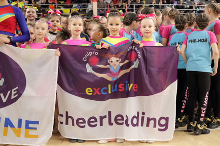 Kamianske, Ukraine - February 16, 2020: cheerleading teams lined up before the awards ceremony, cheerleaders holding a flag, cup of Dnipropetrovsk region from cheerleading among solo, duets and teamsのeditorial素材