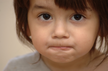 little black eyed boy with firmly closed mouth