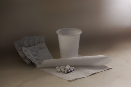 medicines on a paper napkin and cup of water